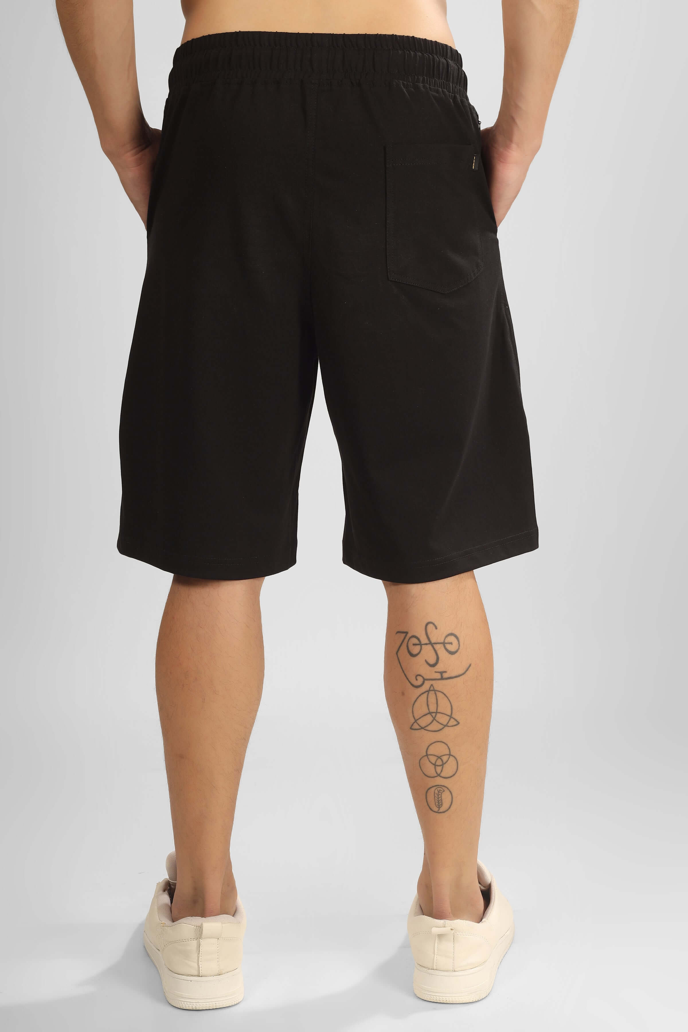 Back view of ROSE REGULAR FIT COTTON SHORTS BLACK being worn, showcasing comfort and stylish design with rose detail.