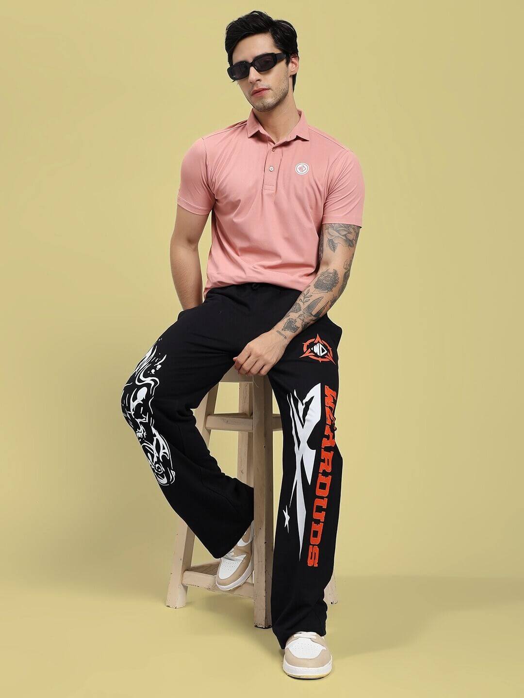 Man wearing ROSEWOOD POLO REGULAR FIT T-SHIRT PINK seated on a stool in a studio setting