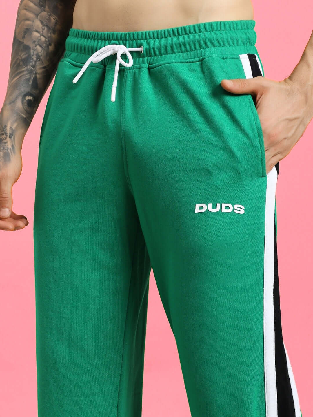 Close-up of ROSSTON FLAT-OUT RELAXED FIT JOGGERS GREEN made from cotton blend fabric, showcasing drawstring detail and logo on leg.