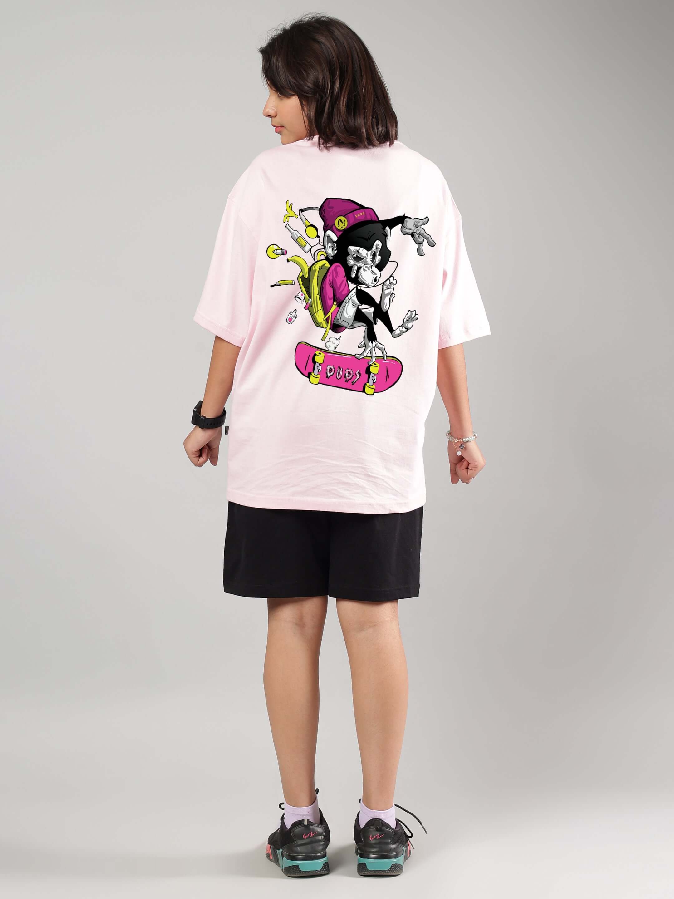 Child wearing ROWDY APE CO-ORD FOR BOYS GIRLS PINK-BLACK outfit with cartoon skater design on back, showcasing trendy streetwear style.