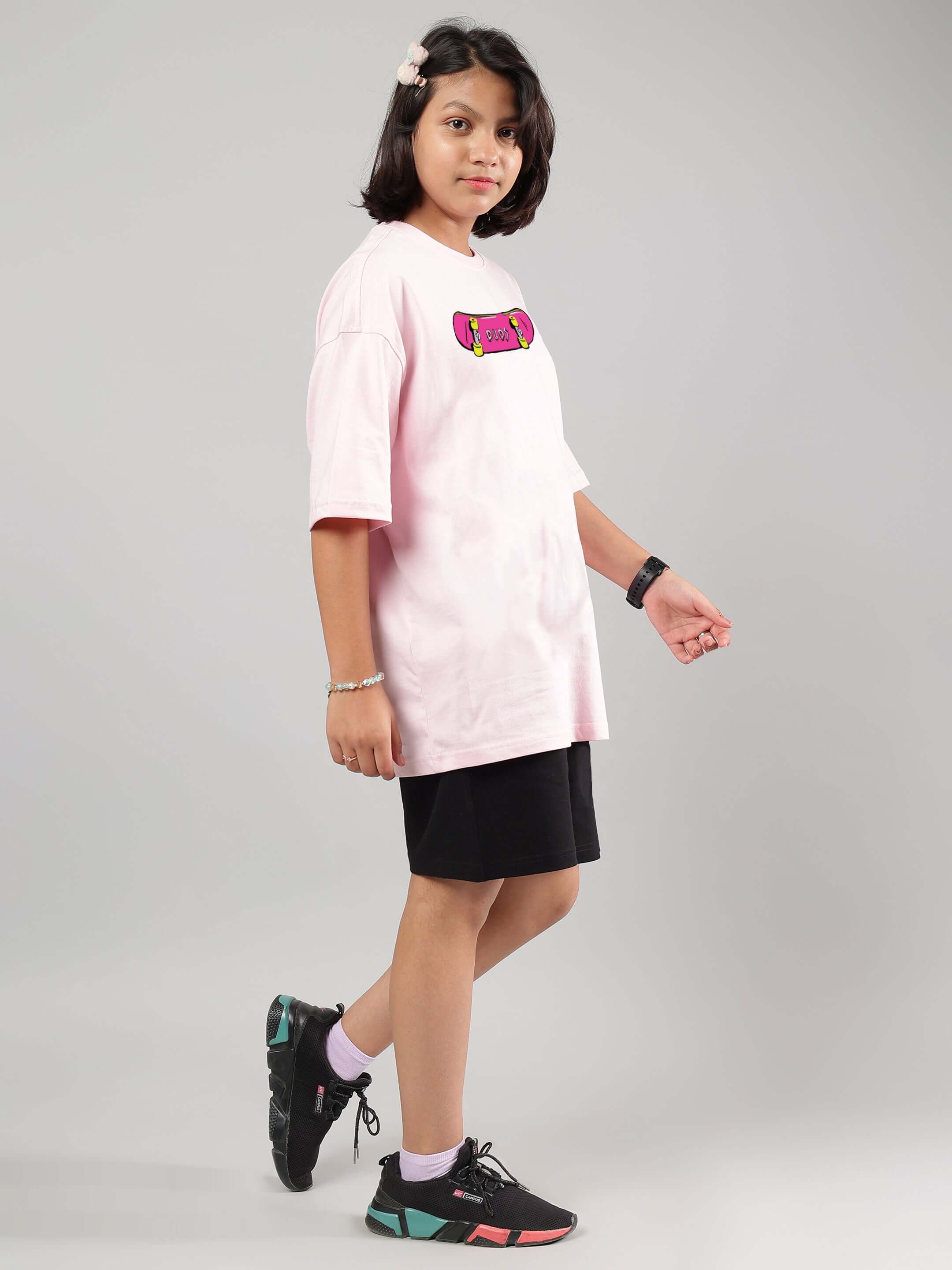 Child wearing ROWDY APE CO-ORD FOR BOYS GIRLS PINK-BLACK outfit, featuring a pink shirt and black shorts, showcasing trendy streetwear style.