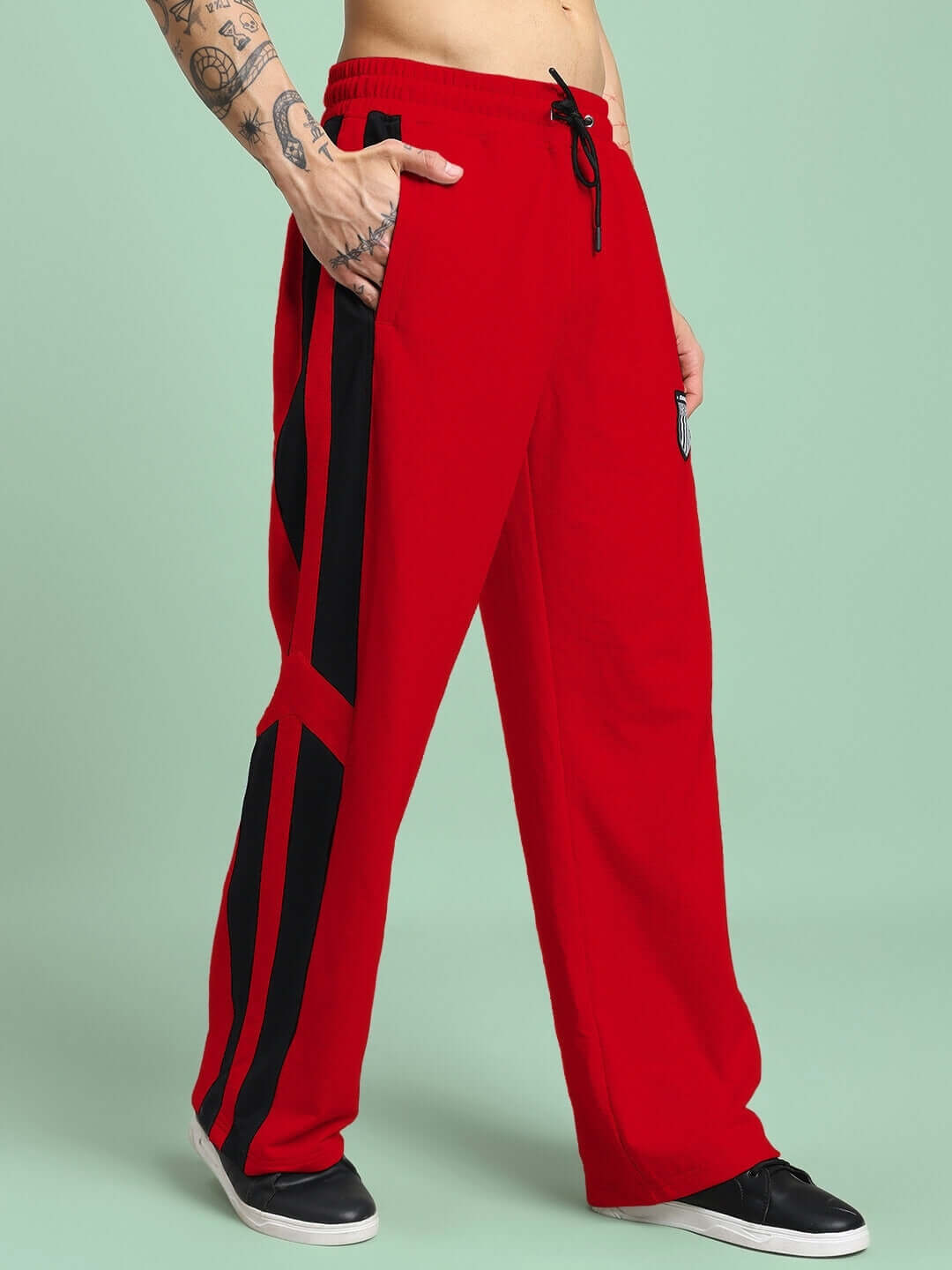 ROYALSON PREMIUM JOGGERS IN RED worn by a tattooed model, showcasing bold style and premium construction in vibrant red.