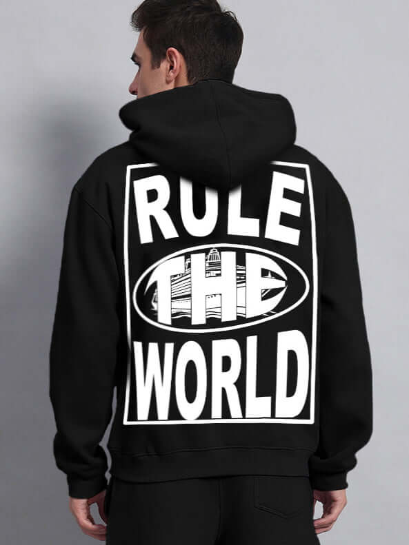 Back view of the RULE THE WORLD OVERSIZED HOODIE BLACK featuring bold text and relaxed fit, perfect for streetwear enthusiasts.