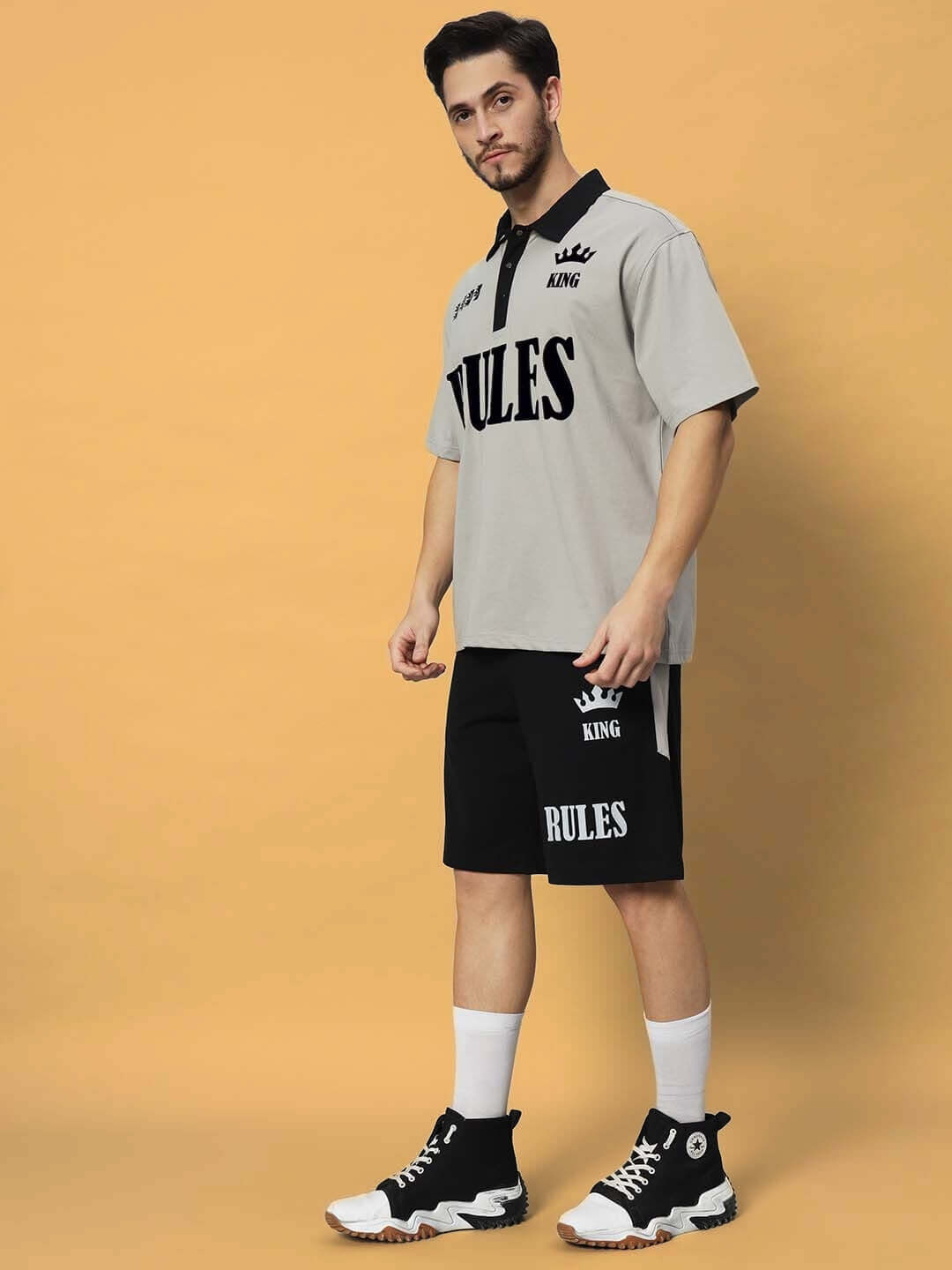 Model wearing grey-black RULES KING co-ord set made from premium cotton French terry, styled with black high-top sneakers.