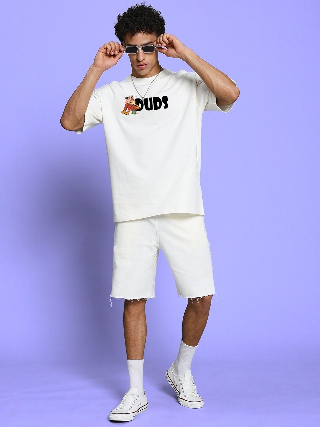 Model wearing SAFARI PRINTED CO-ORD SET OFF-WHITE, featuring oversized tee and shorts with safari-inspired prints, against purple backdrop.