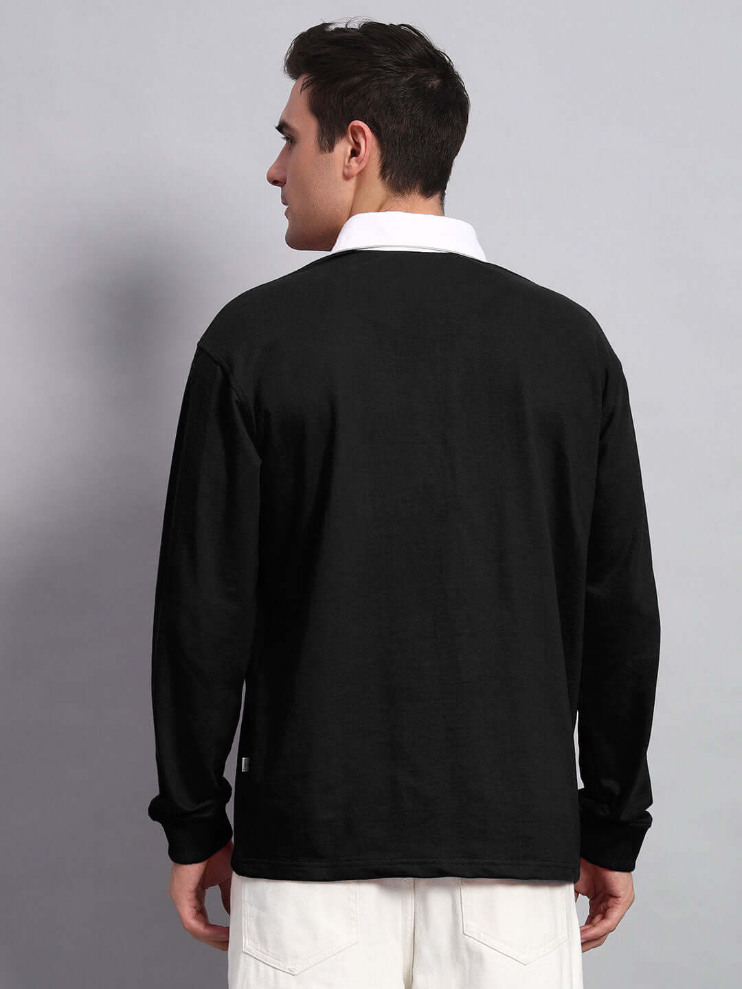 Back view of SAGOL black oversized polo sweatshirt, premium cotton fabric, styled on male model. Comfortable and stylish design.