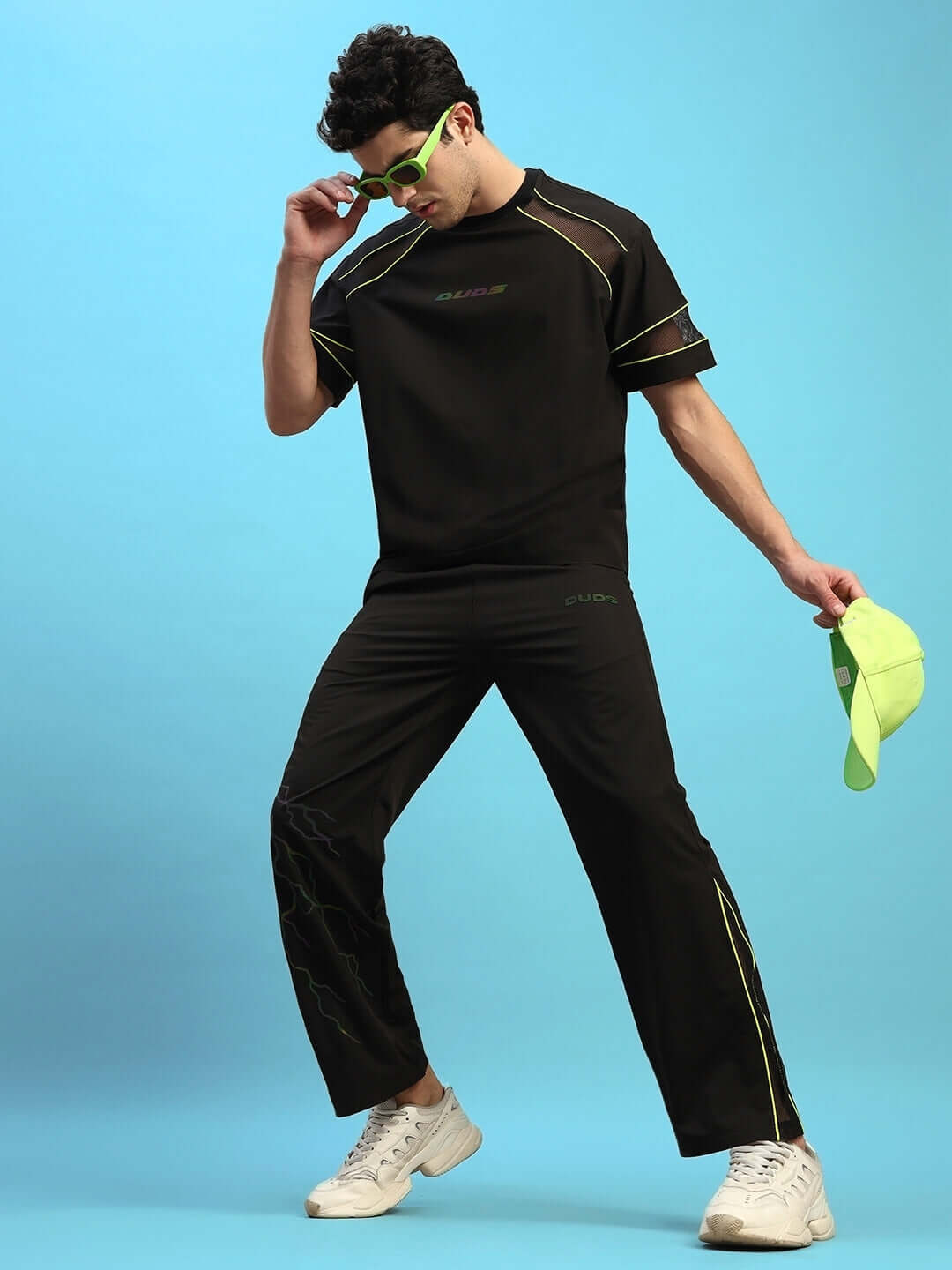 Person wearing SALVO REFLECTOR CO-ORD SET in black, showcasing premium sports polyester fabric, accessorized with sunglasses and a cap.
