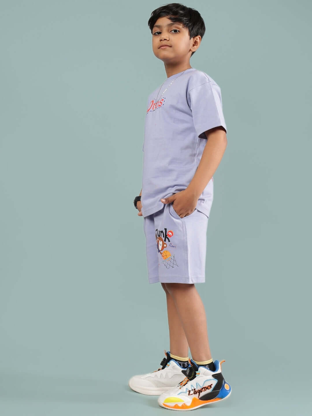 A child wearing the SAMMY CO-ORD FOR BOYS & GIRLS LAVENDER set, showcasing lavender short sleeves and shorts with graphic details.