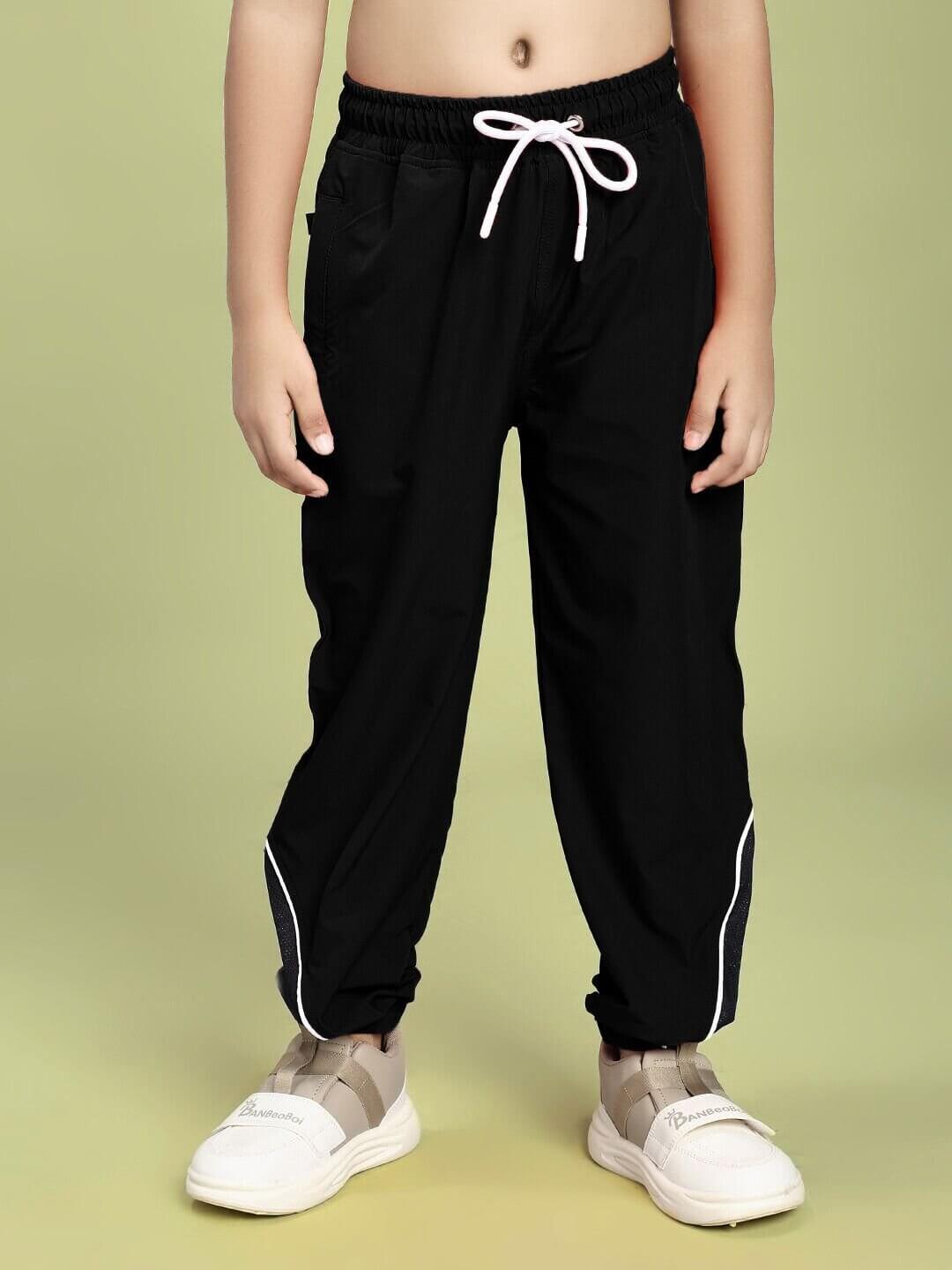 Child wearing SAMURAI SOUL PRINTED CO-ORD FOR BOYS AND GIRLS WHITE BLACK pants standing against green background