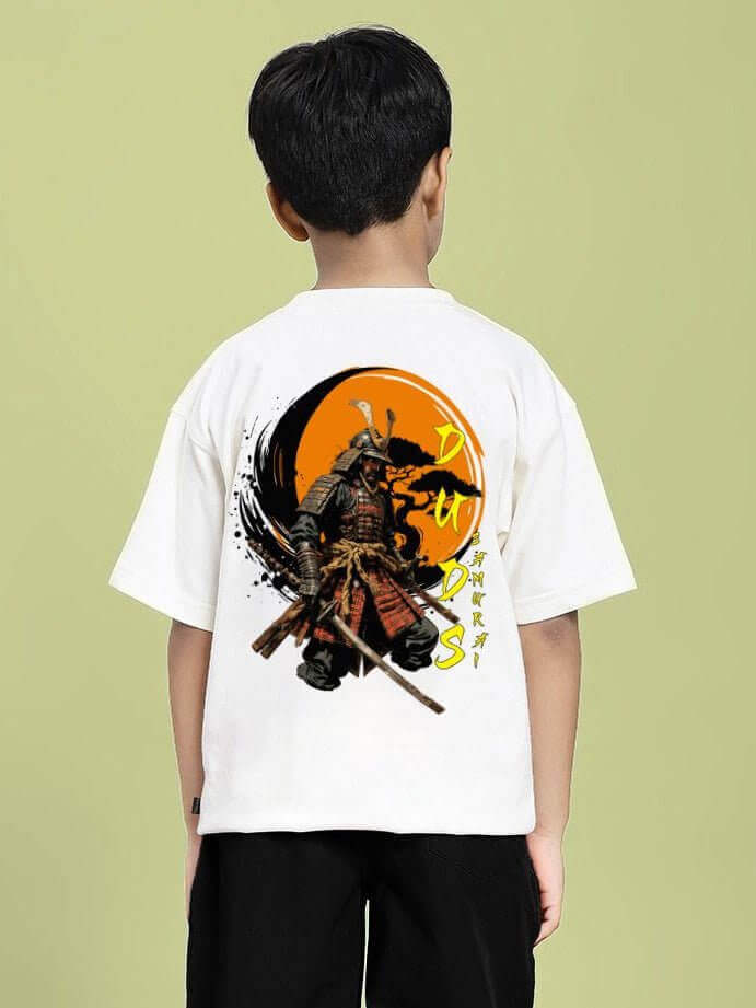 Boy wearing the SAMURAI SOUL PRINTED T-SHIRT FOR BOYS AND GIRLS WHITE with a samurai graphic design and black pants in front of a green background.