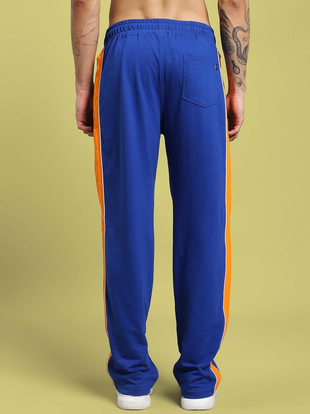 Rear view of SANFORD STRIPE JOGGERS BLUE featuring orange side stripes, showcasing the detailed design and fit for athletic style.
