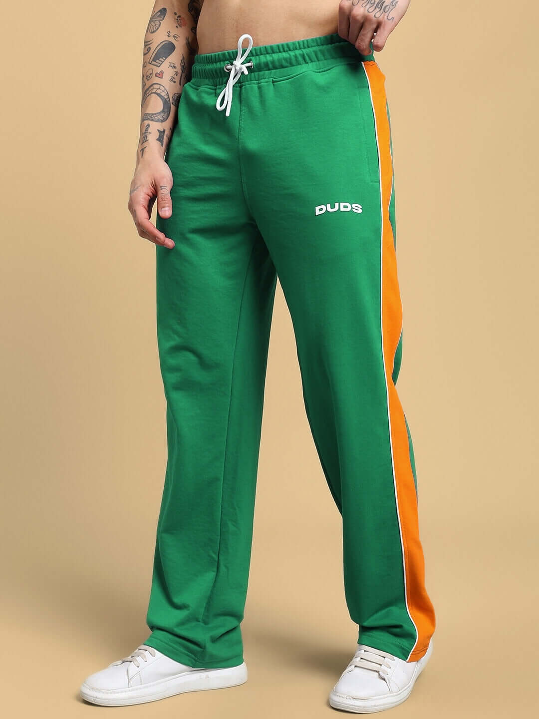 SANFORD STRIPE JOGGERS IN GREEN with orange side stripe, modeled with casual white sneakers.
