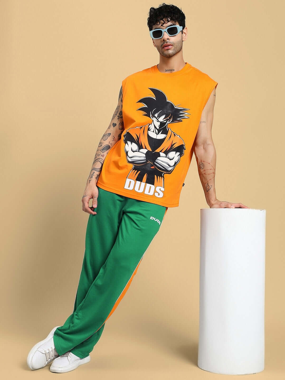 Man wearing SANFORD STRIPE JOGGERS IN GREEN with a graphic tank top, showcasing casual and stylish streetwear fashion.