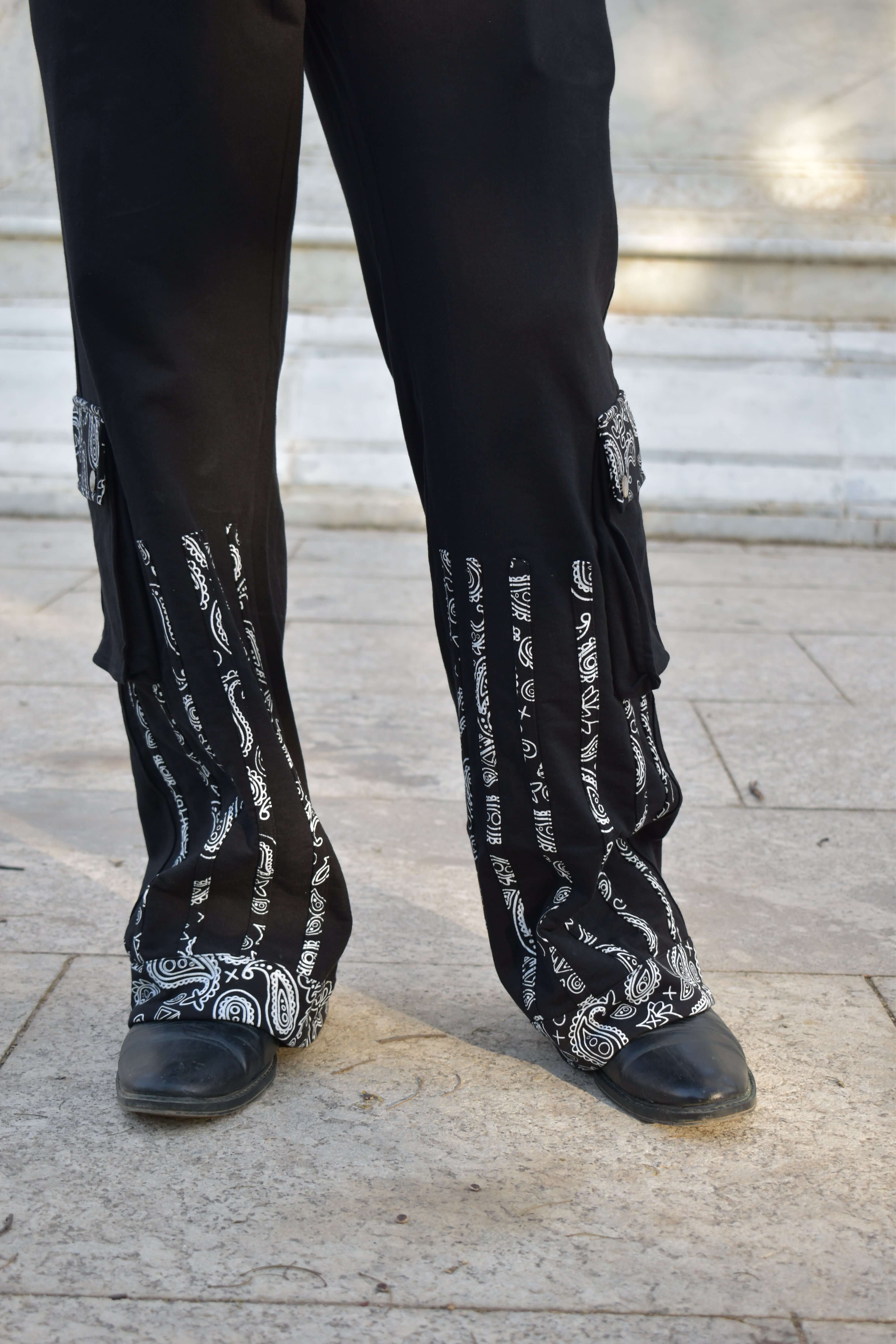 Woman wearing SANGANERI THE GREAT JOGGERS BLACK with streetwear design on stone pavement.