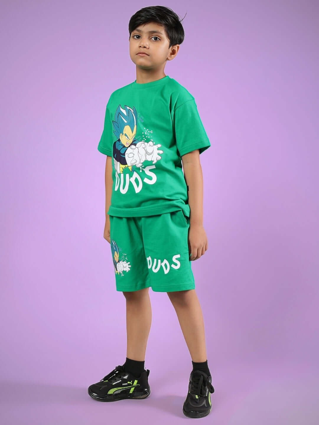 Boy wearing SATORU CO-ORD FOR BOYS & GIRLS GREEN outfit by DUDS, featuring a stylish matching T-shirt and shorts against a pink background.