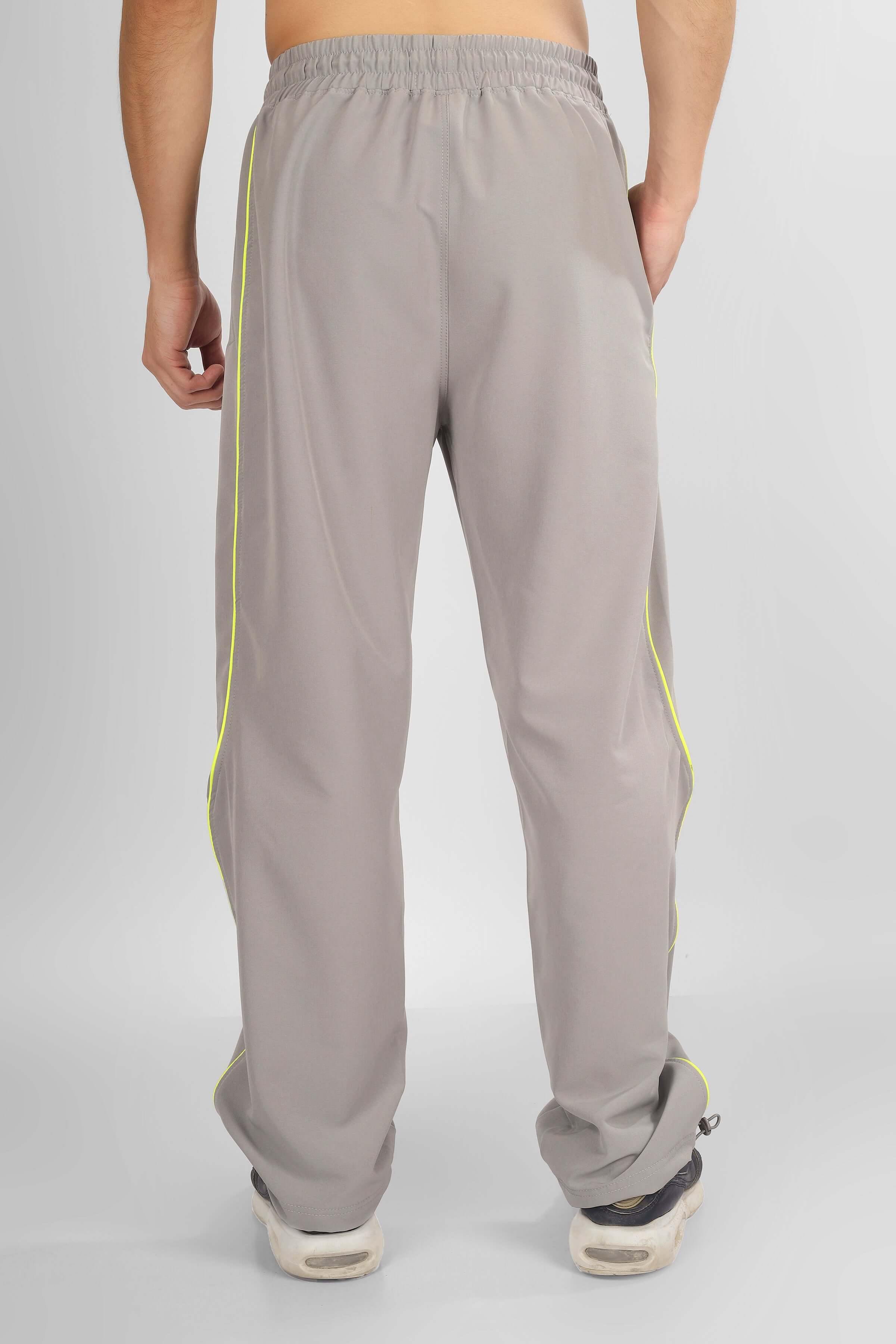 Back view of grey scoop parachute cargo pants with custom fit option and neon yellow side stripes
