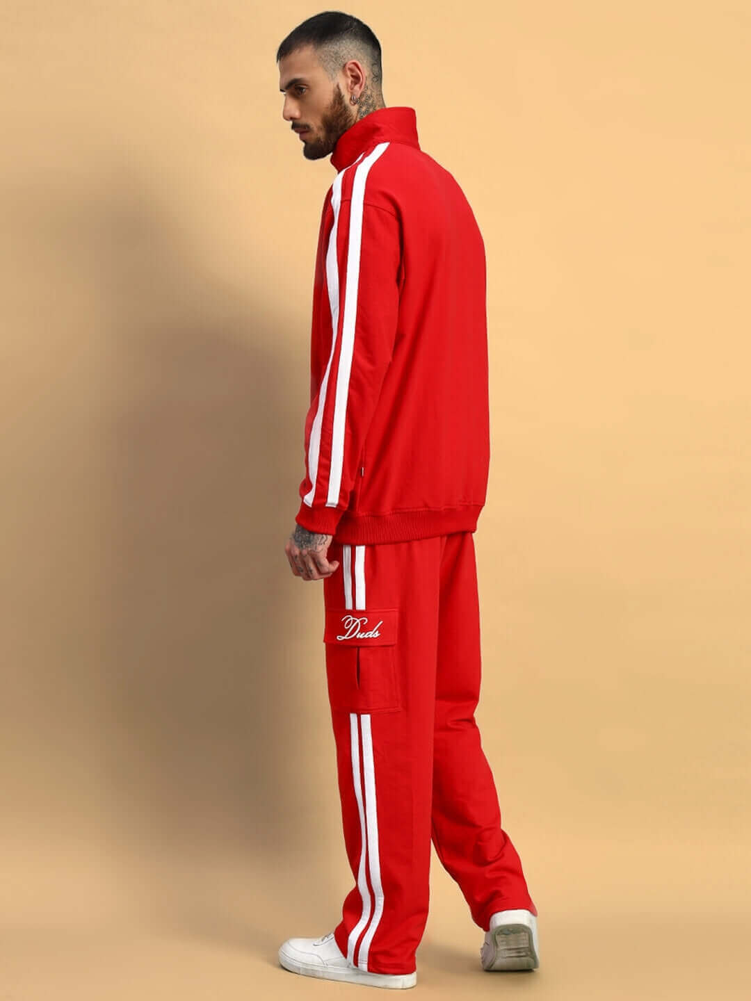 Man wearing red Scotia Stripe Joggers with white stripes by DUDS, showcasing a stylish and comfortable fit in a side profile view.