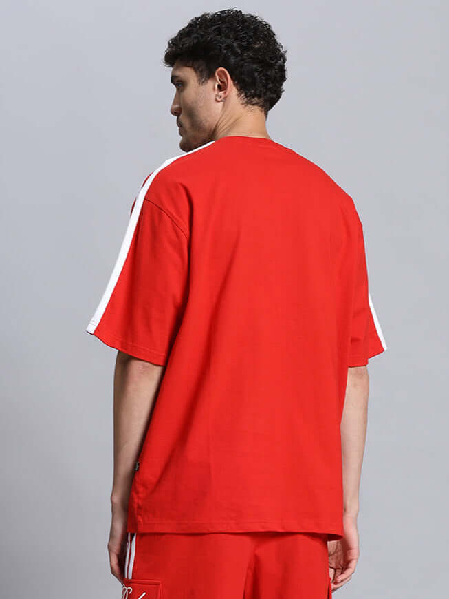 Back view of model wearing SCOTIA OVER-SIZED COTTON T-SHIRT RED, showcasing bold design and comfort.