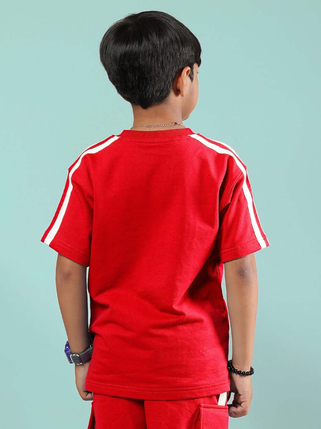 Boy wearing a SCOTIA T-SHIRT FOR BOYS & GIRLS RED, back view, highlighting vibrant color and style, suitable for children.