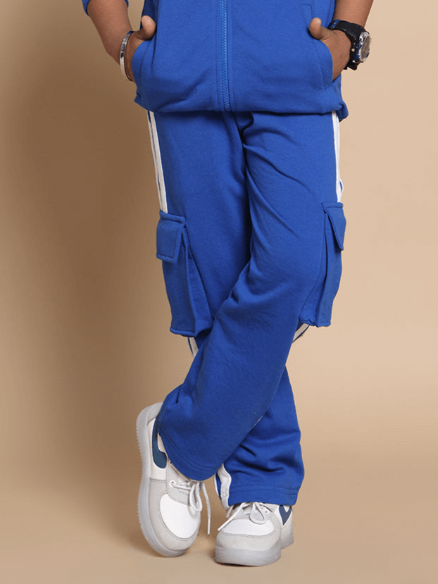 Royal blue joggers with white stripes for kids, featuring side pockets. Comfortable, stylish sportswear by DUDS, ideal for boys and girls.