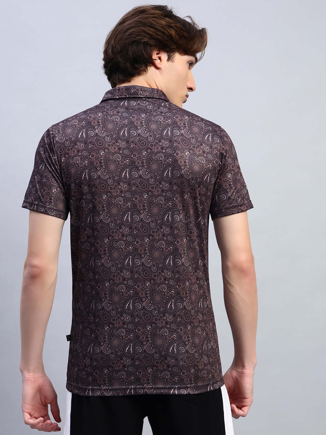 Back view of a man wearing a Scottish regular fit brown T-shirt made of sports polyester fabric with a paisley design.