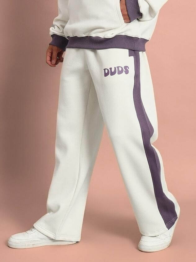 Person wearing SELF LOVE FLEECE PANT WHITE VIOLET, showcasing relaxed fit and ribbed hems.