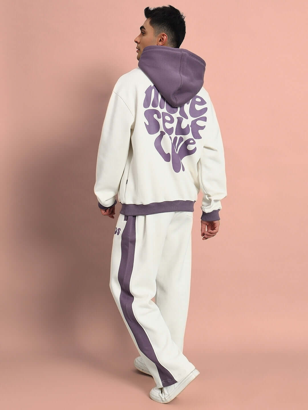 Back view of SELF LOVE FLEECE OVERSIZED HOODIE WHITE VIOLET showing graphic text and oversized fit on a model against a pink background.