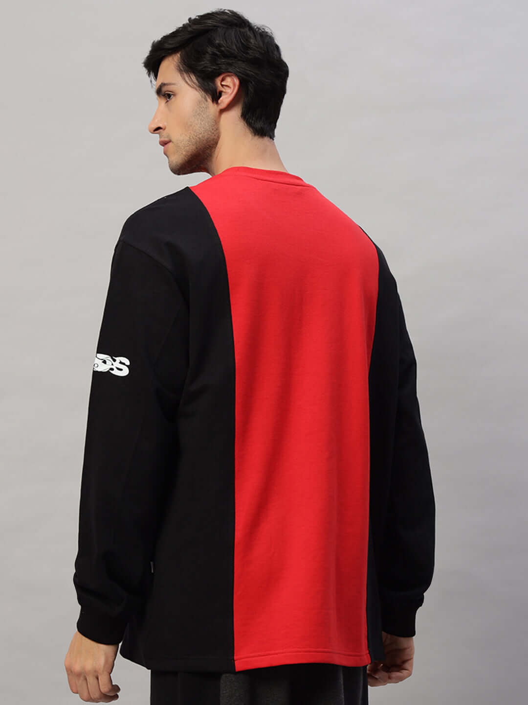 Model wearing SELF-RULE oversized sweatshirt in black and red, featuring premium cotton French terry fabric, side view.