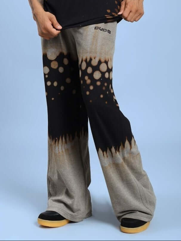 Person wearing SHADOW SWIRL TIE-DYE JOGGER BLACK with unique black swirl design against blue background.