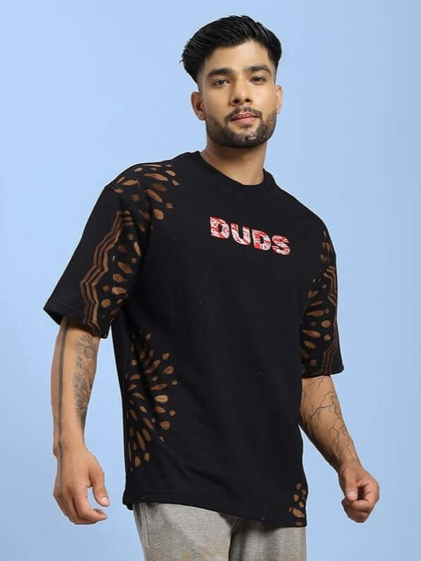 Model wearing SHADOW SWIRL TIE-DYE T-SHIRT BLACK showcasing the unique swirl design and casual style against a light background.