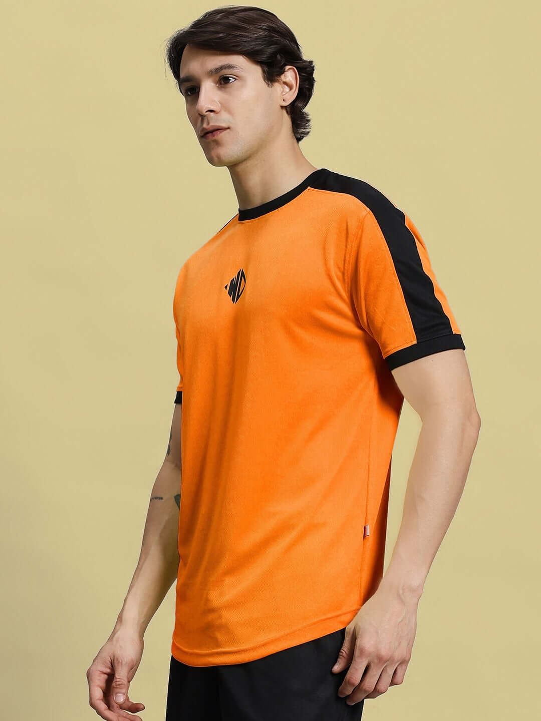 Man wearing SHERPA REGULAR FIT T-SHIRT ORANGE sports polyester fabric, perfect for active wear.