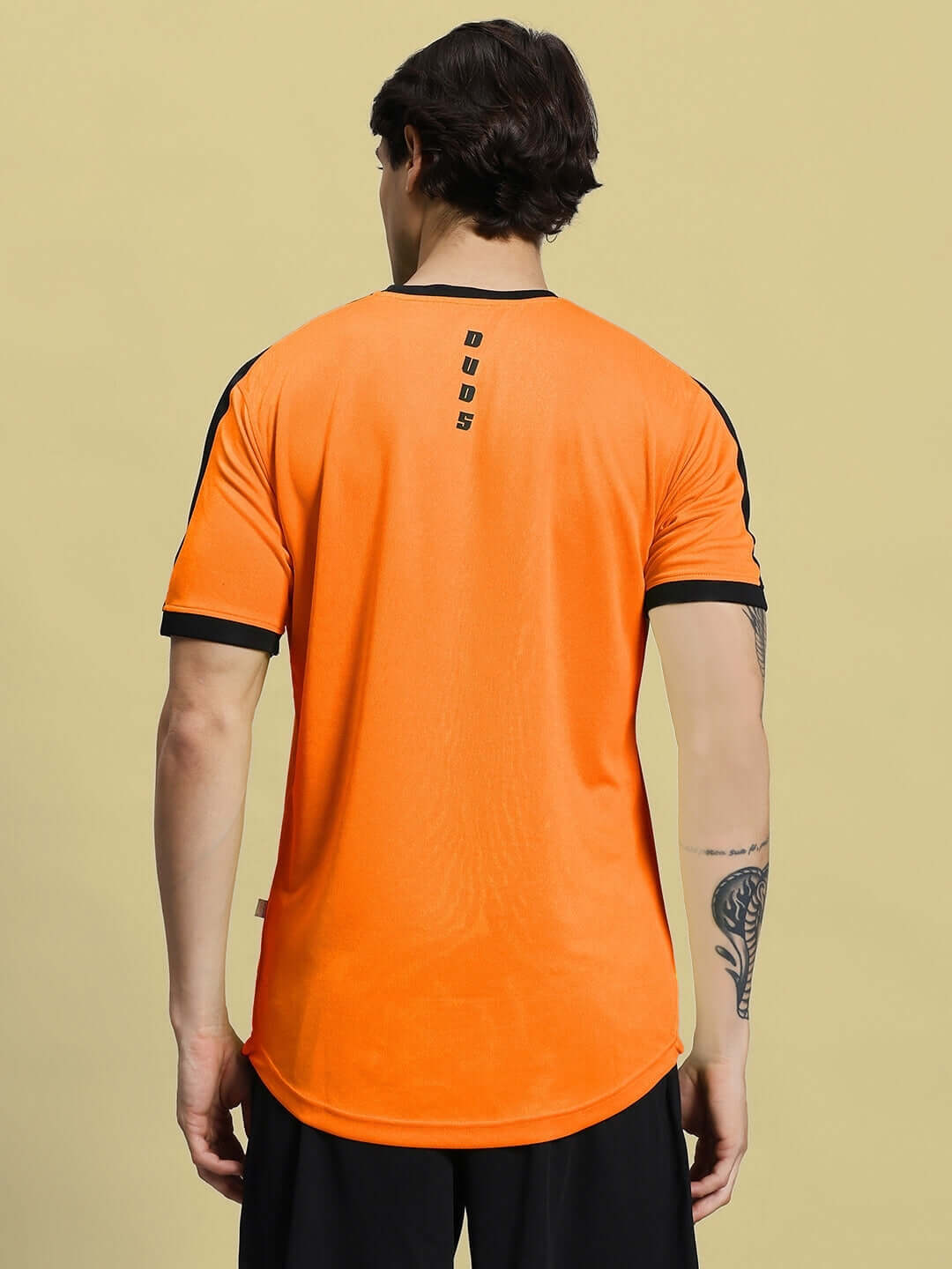 Back view of SHERPA REGULAR FIT T-SHIRT ORANGE in sports polyester fabric, showing design and fit.