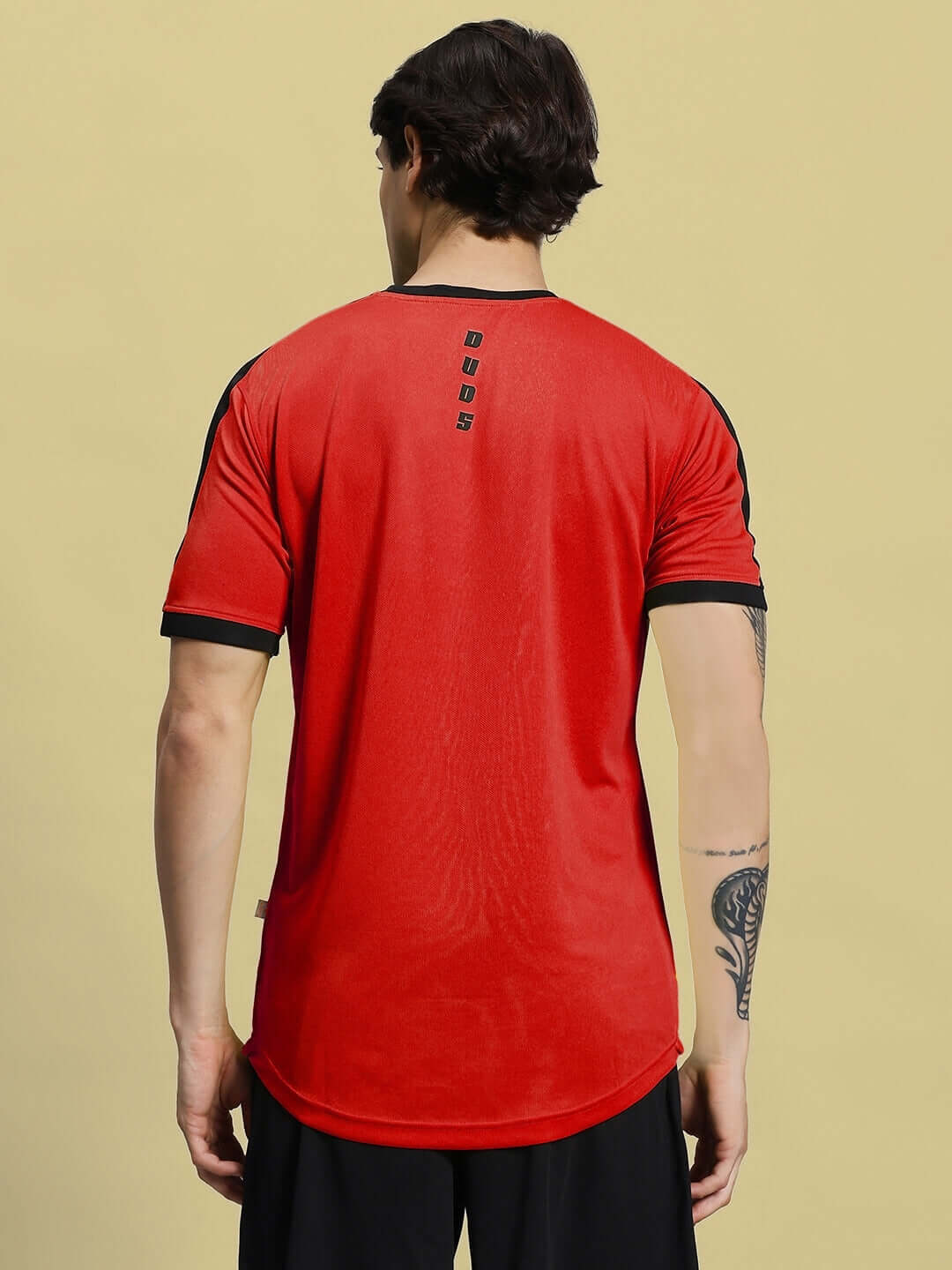 Back view of a man wearing a SHERPA REGULAR FIT T-SHIRT RED made of sports polyester fabric.