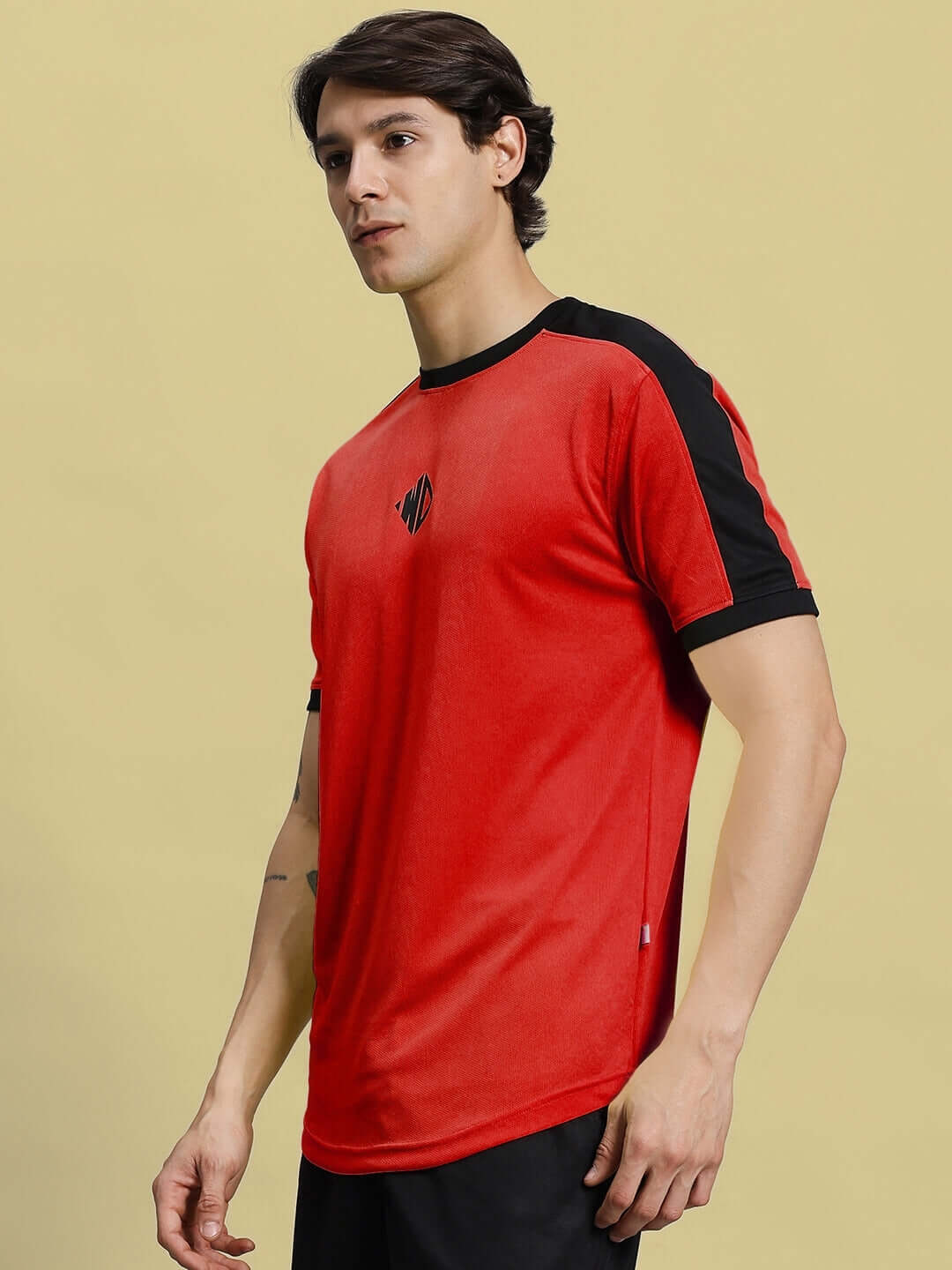 Man wearing SHERPA REGULAR FIT T-SHIRT RED made of sports polyester fabric, showcasing its sleek design with black accents. Cold machine wash recommended.