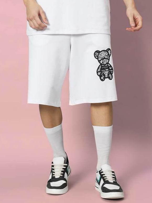 SHIMMY REGULAR FIT SHORTS WHITE for kids featuring a black bear print, styled with sneakers for a versatile and comfortable look.