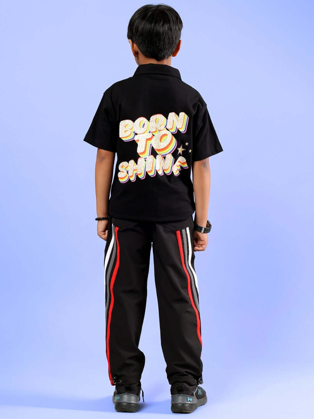 Child wearing SHINE CO-ORD FOR BOYS & GIRLS BLACK with 'Born to Shine' print on back, displaying a stylish outfit made by DUDS, perfect for kids.
