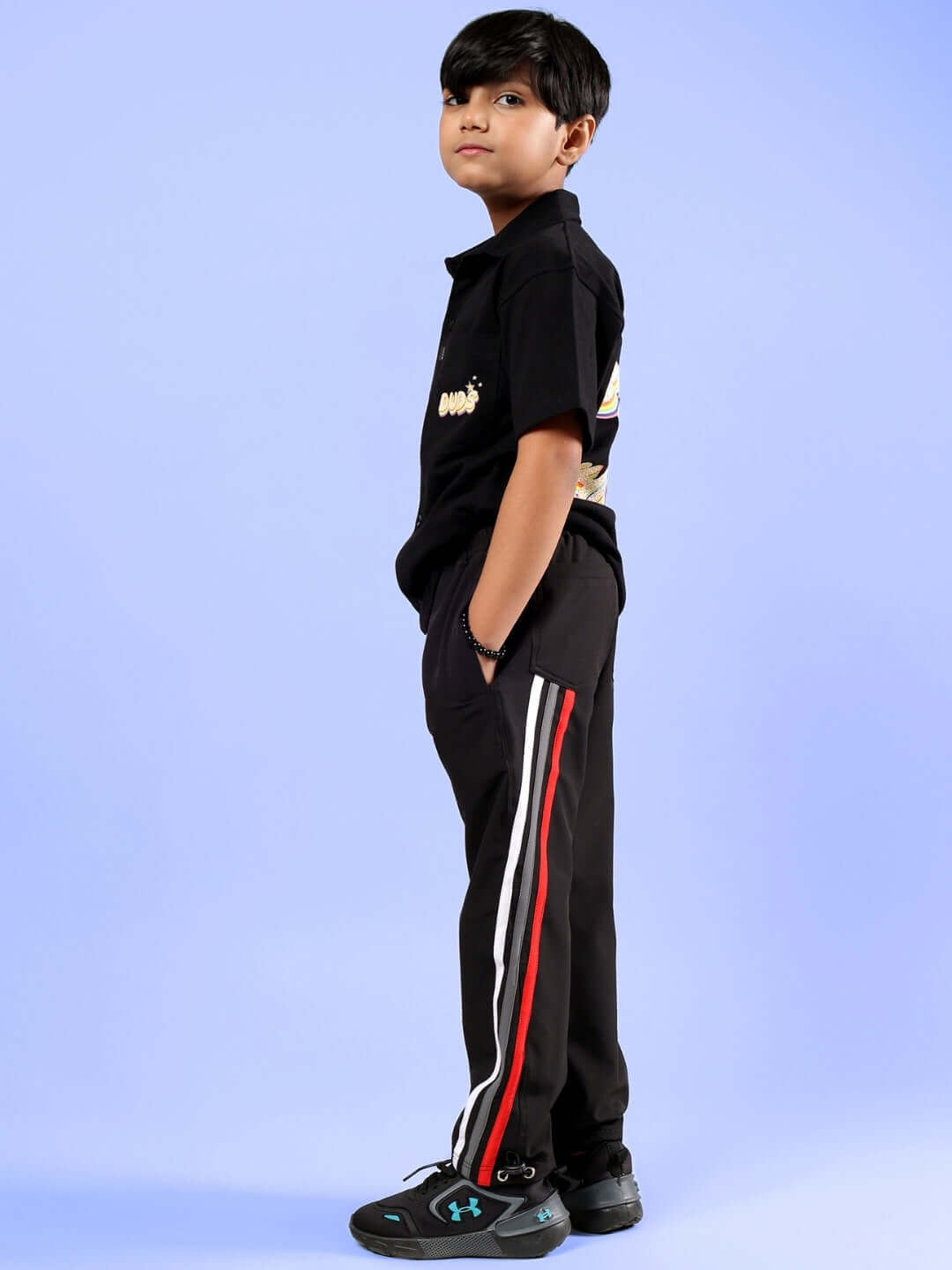 Boy modeling SHINE CO-ORD FOR BOYS & GIRLS BLACK outfit with side stripes.