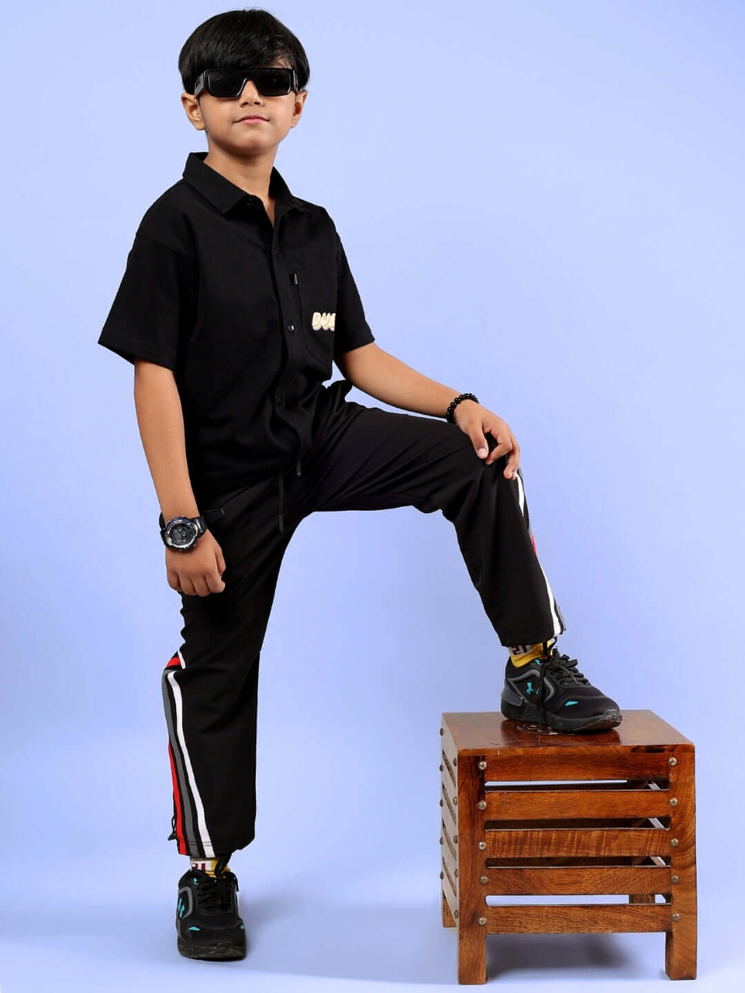 Alt Tag: Boy wearing SHINE CO-ORD FOR BOYS & GIRLS BLACK outfit, standing on a wooden stool. Casual, stylish look for kids.
