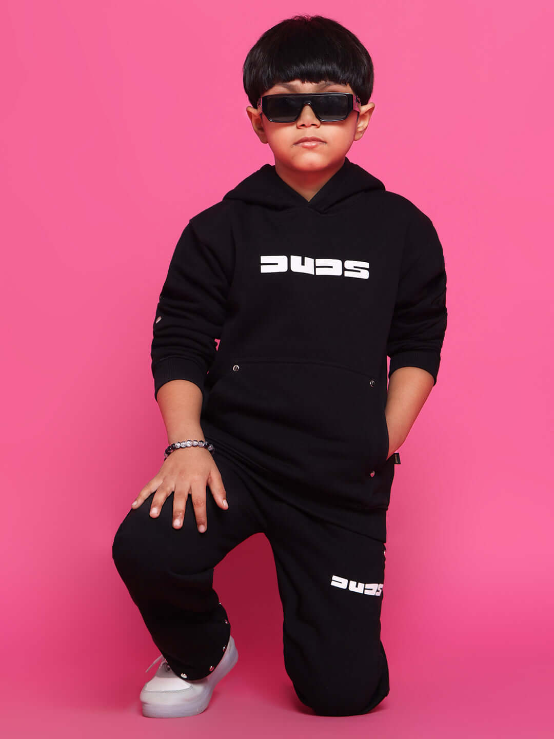 Child wearing Shooter Co-ord set for boys and girls in black by Duds, posing confidently on a pink background, perfect for stylish outfits.