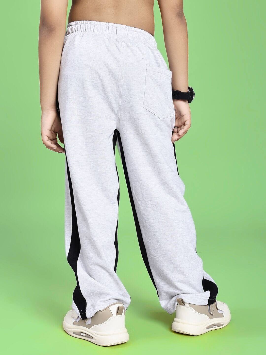 SIDE SEAM BAGGY JOGGER FOR BOYS AND GIRLS GREY BLACK, comfortable fit with contrasting black side panels, casual style pants on green background