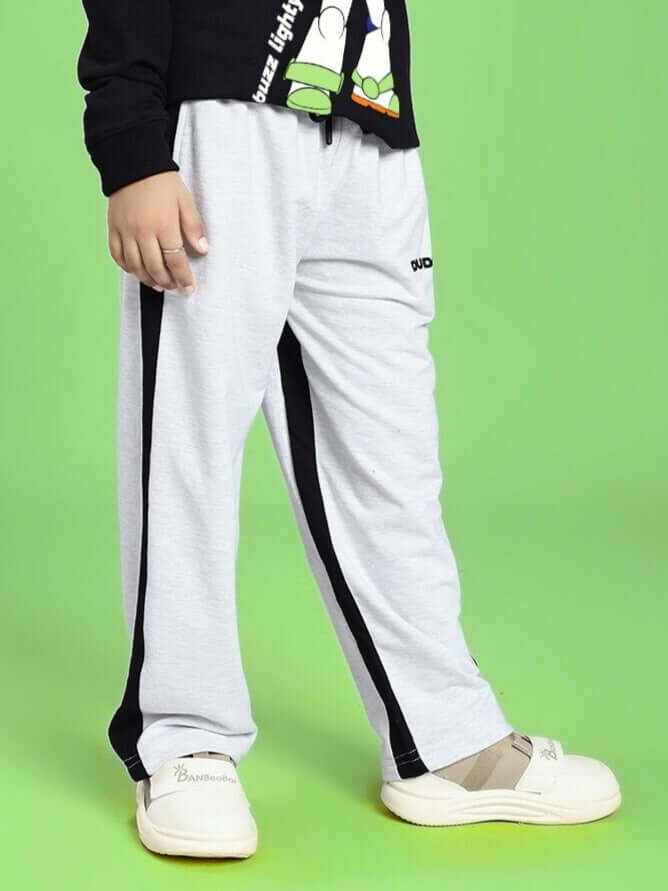 SIDE SEAM BAGGY JOGGER FOR BOYS AND GIRLS GREY BLACK shown on model against green background