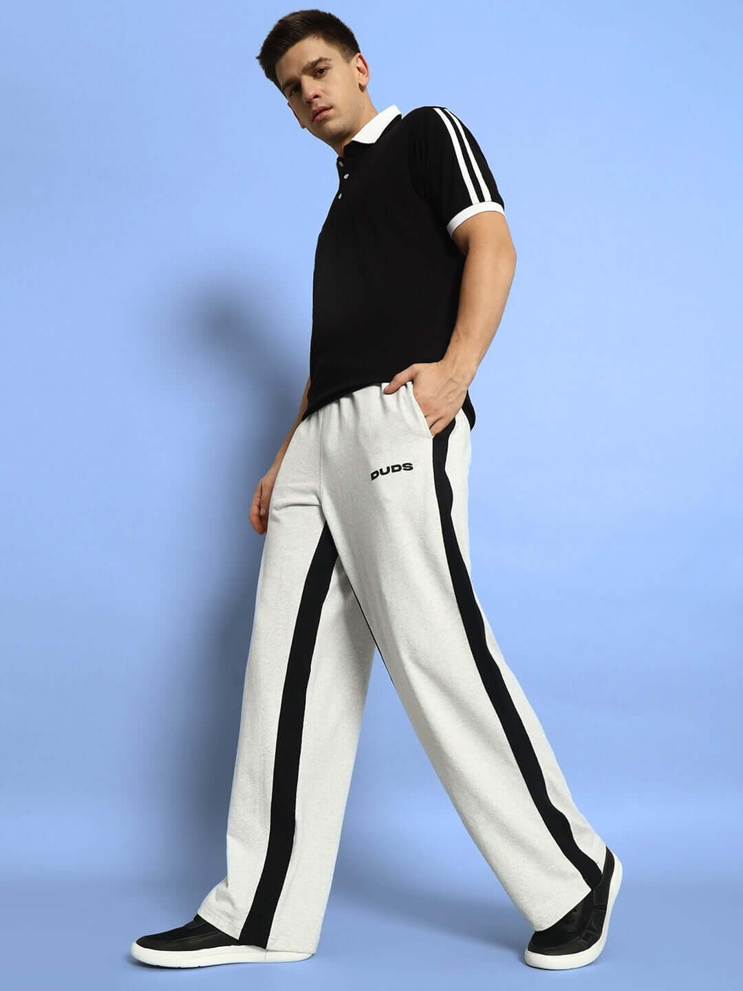 Man wearing SIDE SEAM BAGGY JOGGERS in melange grey-black, showcasing a casual style with customized fit option by DUDS.