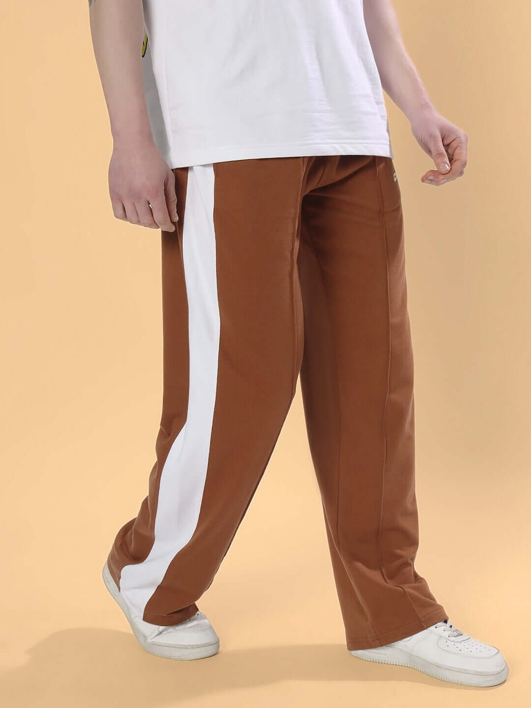 Brown side seam plated joggers with white stripe, custom fit option available, made to order by DUDS, displayed on a model.