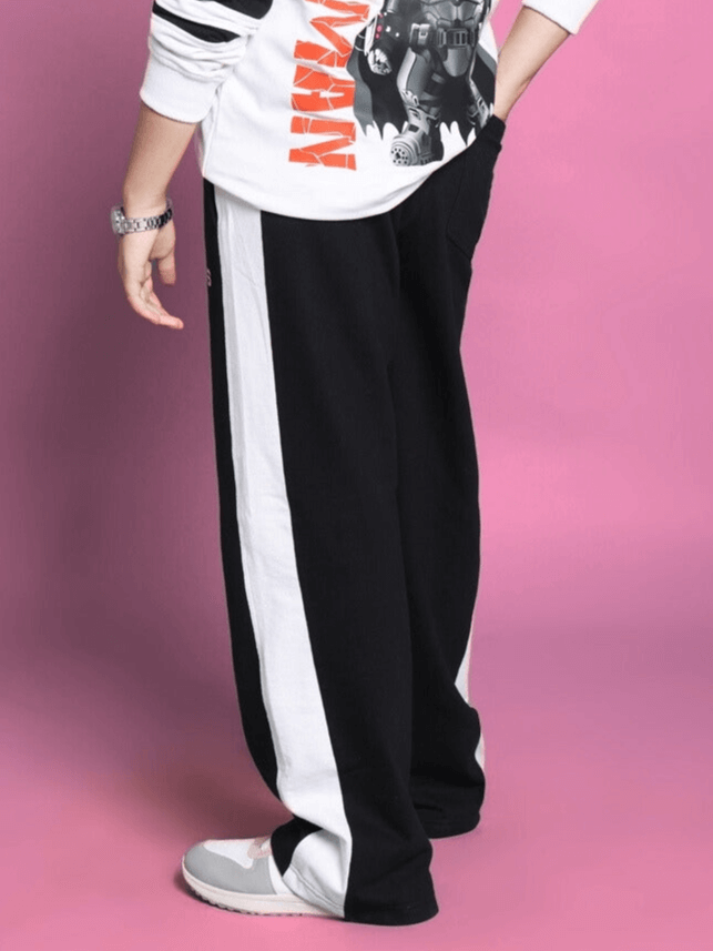 Side seam black baggy jogger pants for boys and girls displayed on a pink background, showcasing casual style and comfort.