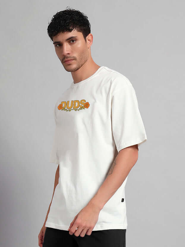 Model wearing off-white oversized t-shirt with sitting lion graphic, styled in premium heavy gauge fabric. Fashionable, comfortable, premium quality.