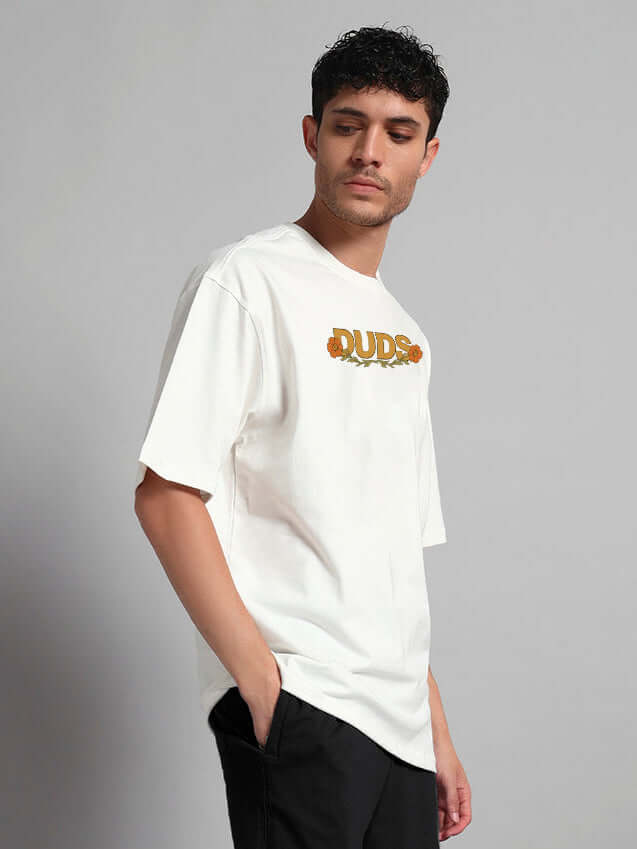 Man wearing oversized off-white t-shirt with 'DUDE' print, made from premium cotton French terry, side profile view.