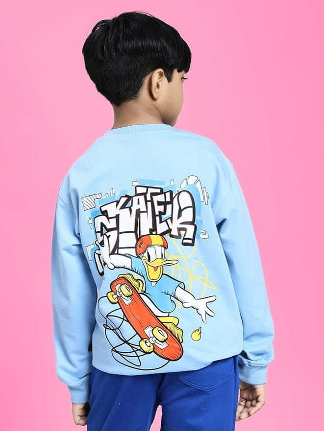 Boy wearing SKATER DUCK SWEATSHIRT FOR BOYS AND GIRLS SKY BLUE with skater duck graphic, pink background