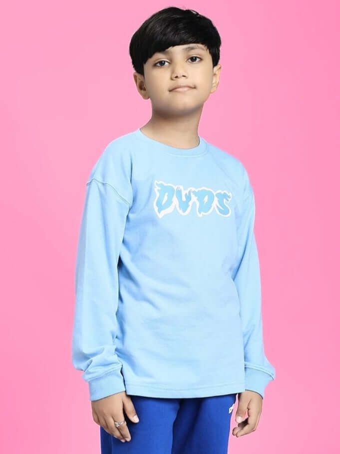 Child wearing SKATER DUCK SWEATSHIRT FOR BOYS AND GIRLS SKY BLUE with skater duck graphic on pink background.
