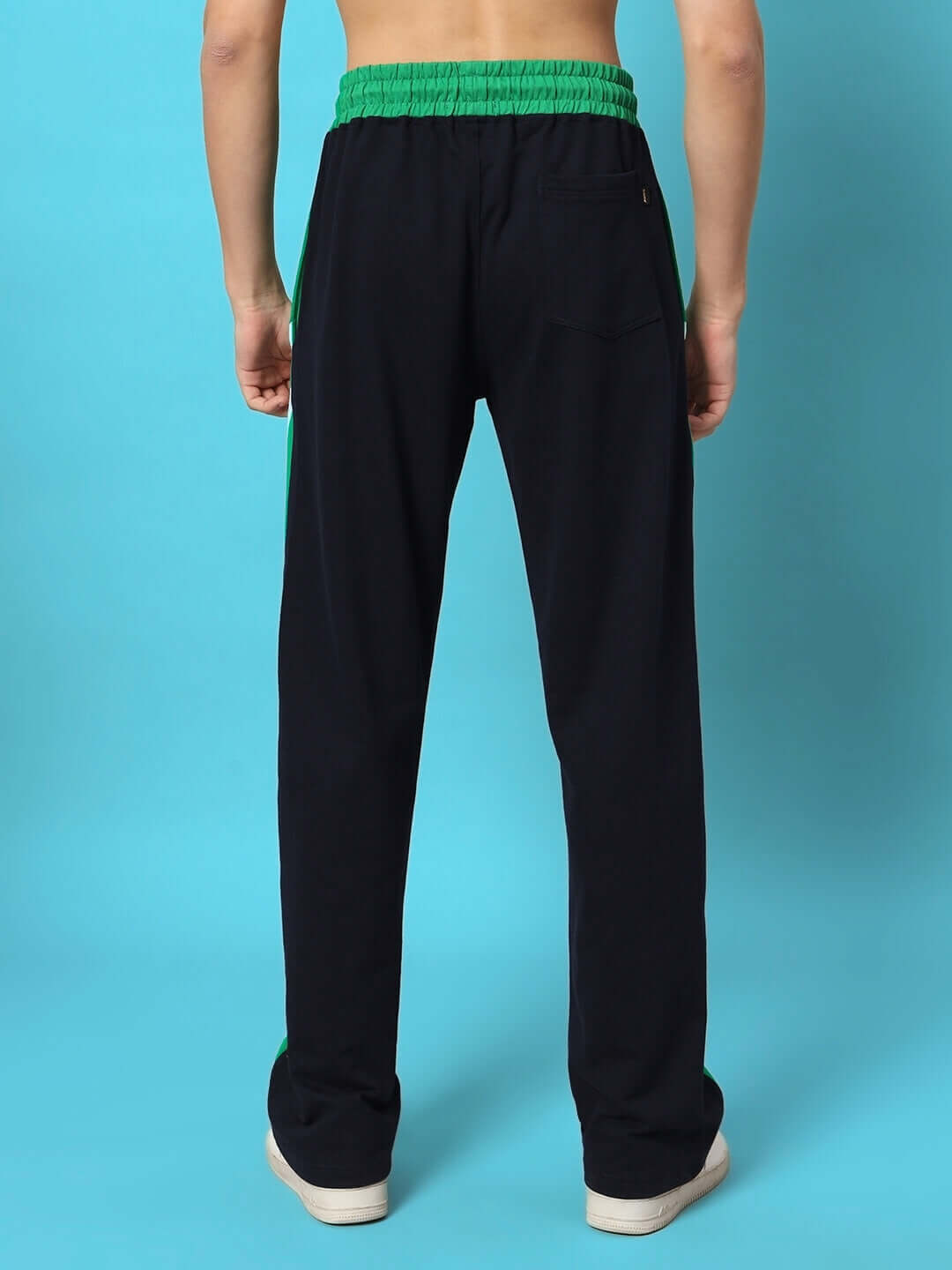 Rear view of SKATER Korean baggy joggers in green and black, showcased against a light blue background.