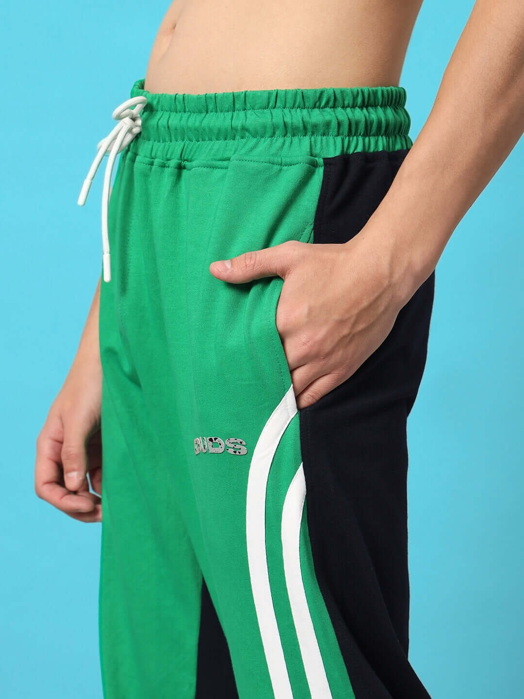Model wearing green and black skater Korean baggy joggers with white drawstring and side stripes, showcasing comfortable fit.